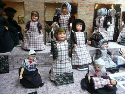Kinderpoppen in geruite dracht.
