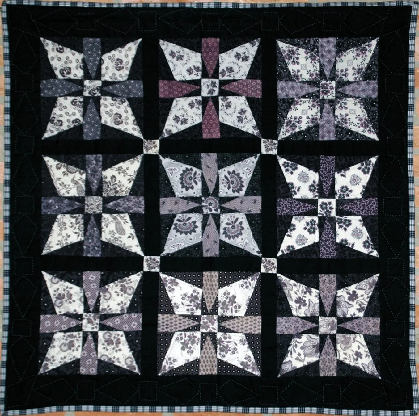 Quilt van Spakenburgse rouwstof met zwarte en witte blokken.