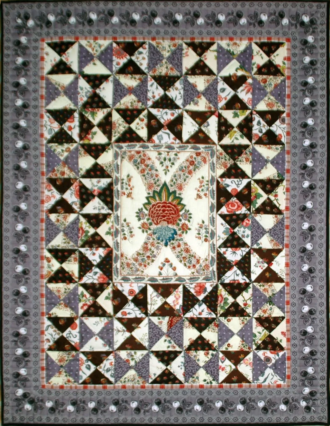 Quilt van Spakenburgse stof met een bloemmotief in het midden.